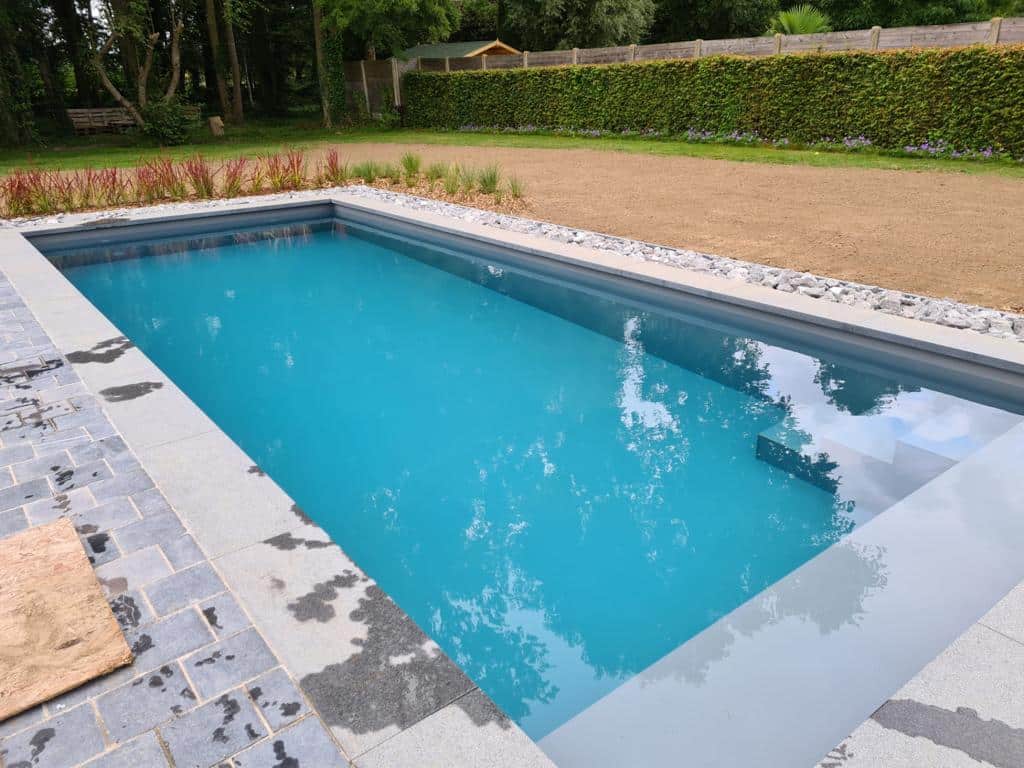 Helderblauw kunststof zwembad in een tuin